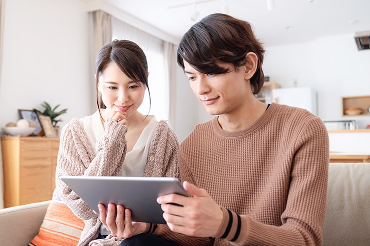 タブレットをみるカップル
